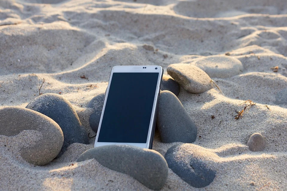 砂浜に置かれたスマートフォン